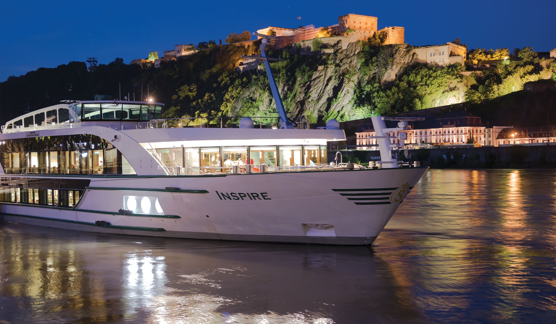 Scenic European river cruise ship passing a historic castle on the Rhine river